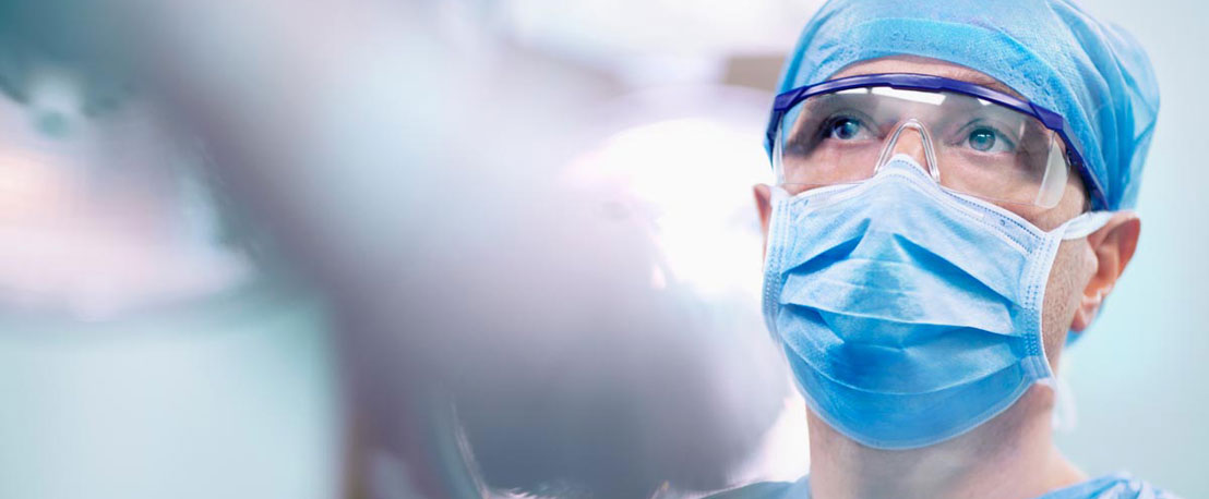 Photo of a healthcare professional wearing a mask in a hospital.