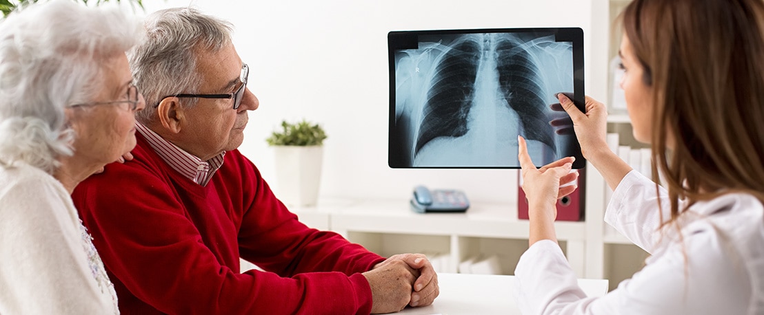 Doctor shows results to old patient x-ray of the lungs