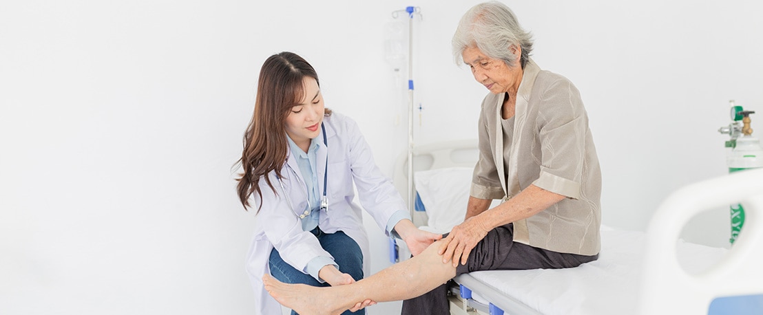 asian female doctor holding leg of old stroke patient in hospital, elderly rehabilitation clinic, they training to rehab muscle, Knee Replacement, Osteoarthritis of the Knee