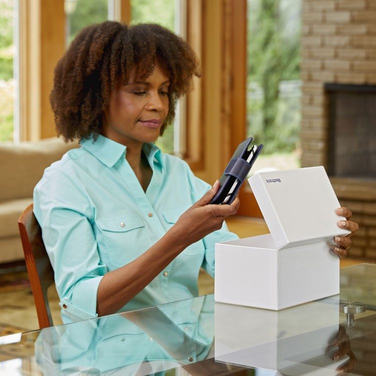 Female patient taking a smart programmer out of a box labeled Medtronic