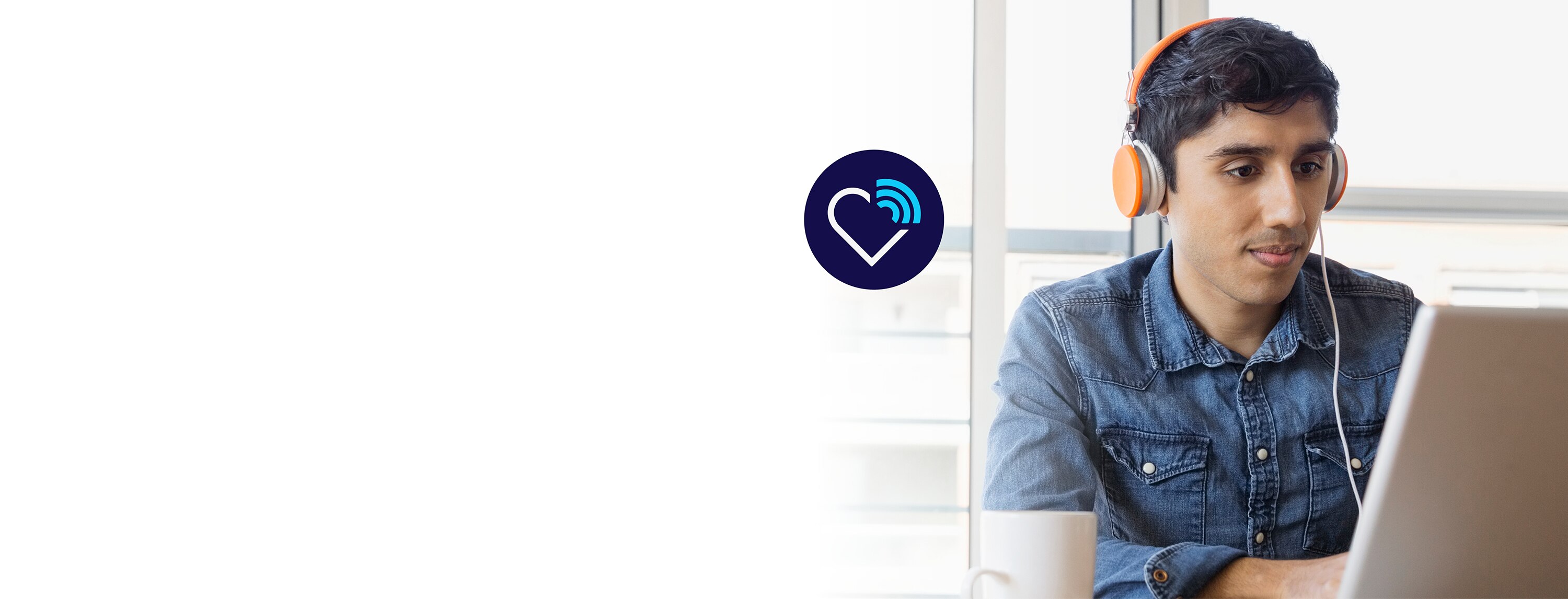 Encircled heart icon with network connection floating next to man wearing orange headphones sitting and looking at laptop