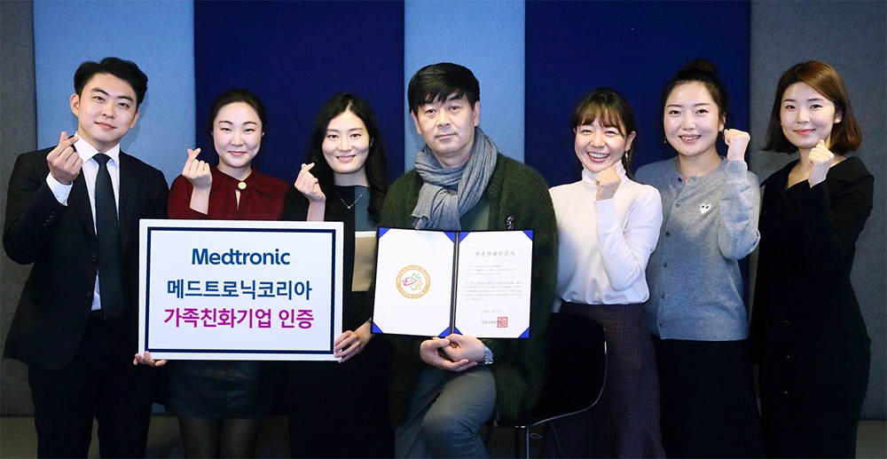 A photo of Medtronic employees holding MWN Family-Friendly certificate
