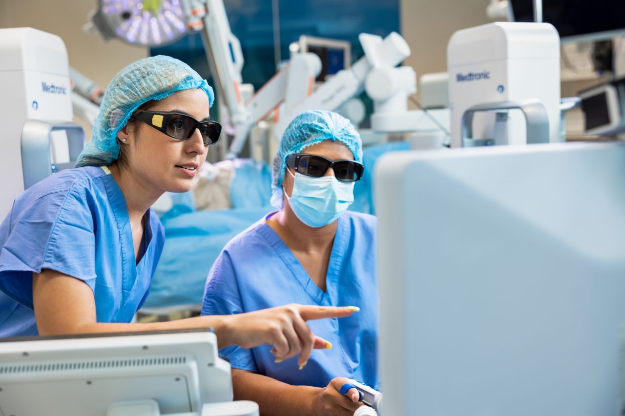 See two doctors talking while looking at a computer.