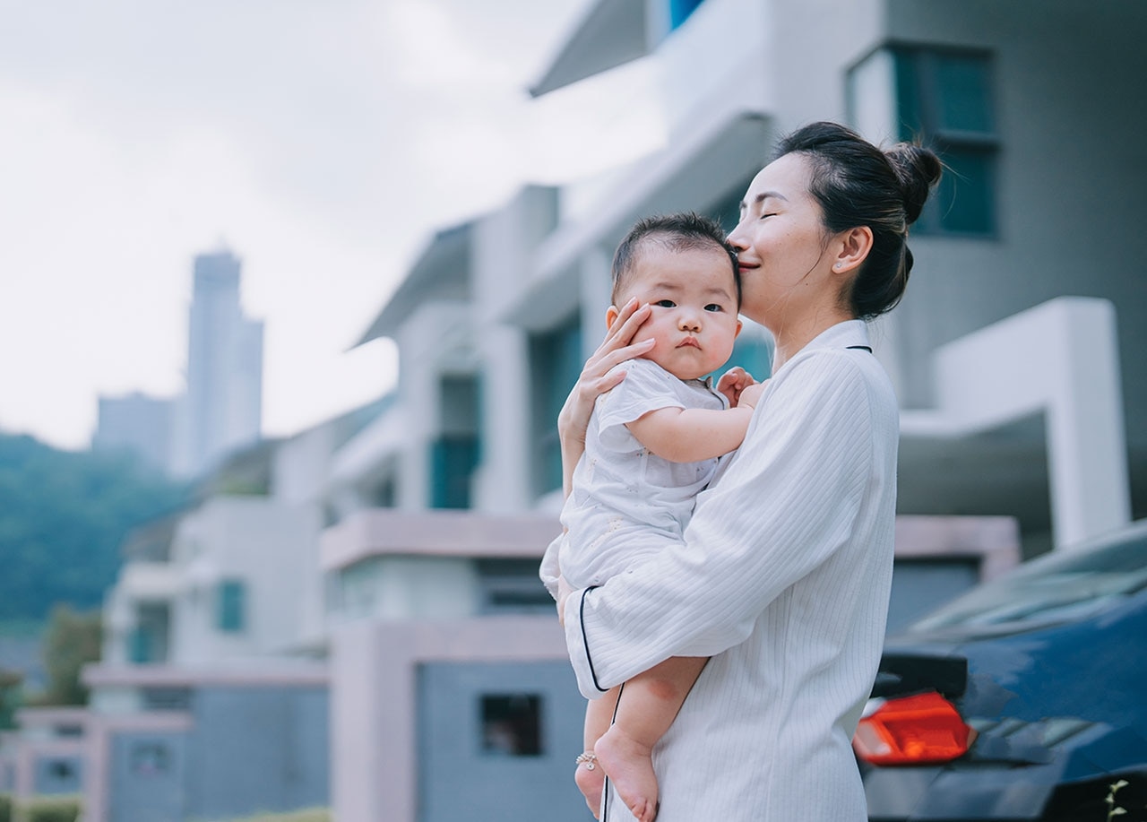 屋外で子供を抱いているアジア人女性