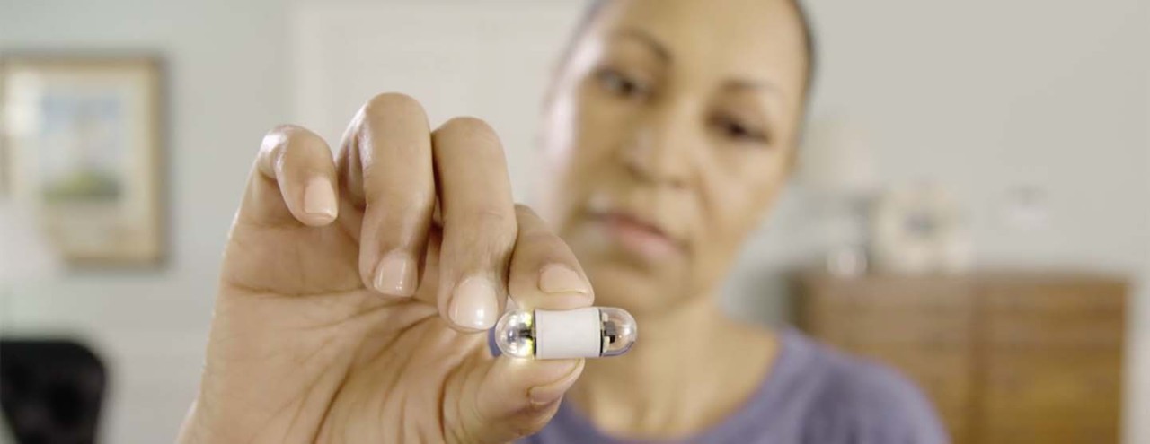 A photo of woman holding a Medtronic pillcam