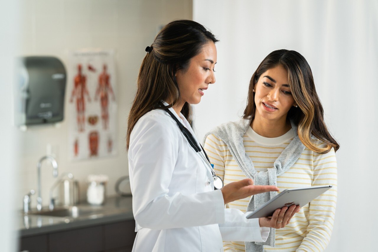 A female healthcare professional talking to a patient and showing her some papers brandcentralphotos