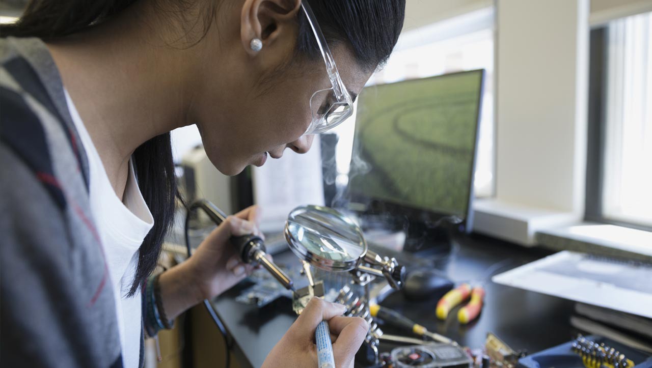 Female engineer soldering her project.  brandcentralphotos