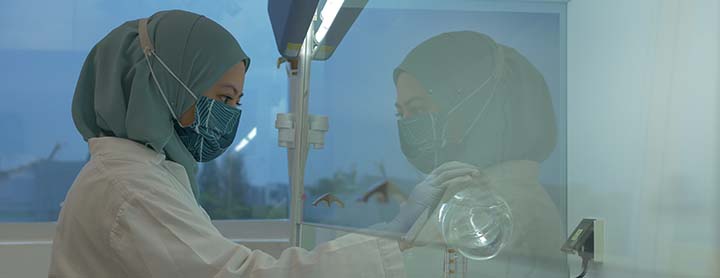 A female scientist in a lab holding a beaker